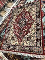 Full view of the handmade Persian style area rug lying flat showing central medallion and border