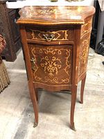Front view of commode showing drawer, door and marquetry top