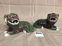 Two foo dog figurines front view on beige fabric