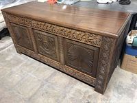 Overall angled view showing top surface and front carved panels