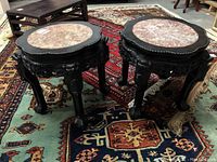 Two stands on oriental rugs showing full view of pair and marble tops