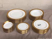 Overall view of five stacks representing dinner plates, salad plates, bread plates, fruit bowls and soup bowls.