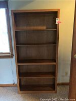 Front view of the wood bookcase showing all five shelves and overall condition.