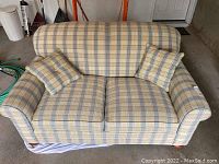 Front view of a plaid patterned love seat with two square plaid cushions, showing the seat and armrests.