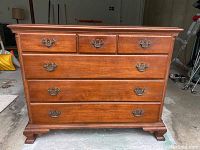 Front view of dresser showing 6 drawers with vintage metal handles