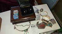 Wide view of two jewelry boxes, assorted bracelets, necklace and loose pieces on table