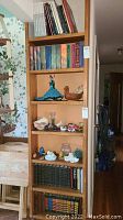 Four shelves of books in a wooden bookcase showing the Harry Potter series, Readers Digest Condensed books, and various classic and reference titles.
