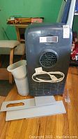 Main portable AC unit with remote, hose, and window panels arranged on floor