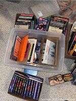 Photo showing plastic tub and boxes containing Star Trek books and comics, some visible titles and colorful covers