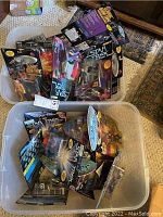 Photo showing two large plastic bins filled with Star Trek Playmates action figures in original packaging, mostly sealed, some opened and taped.