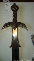 Full view of decorative sword showing detailed dragon-themed hilt and blade.