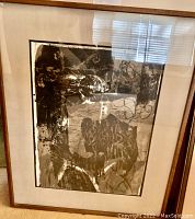 Photo of a framed abstract black and white art print showing layered shapes and textured patterns.