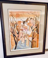 A framed art print by George Lambert, depicting a geometric cityscape scene with muted orange and beige tones, signed and numbered XXIII/LX.