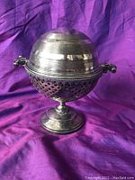 Front view of the antique silver butter dish on a purple cloth background.