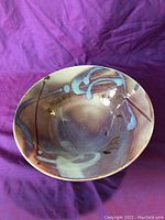 Top view photo showing the hand-painted abstract design in blues, browns, and purples on the large bowl.