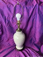 Full view of the MCM ceramic lamp showing white ceramic body, brass fittings, and wooden base.