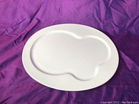 Top view of the white ceramic serving platter showing its oval shape and recessed groove design.