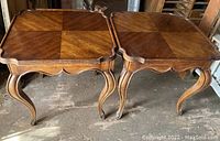 Two square wooden side tables with patterned tops and cabriole legs, showing vintage wear.