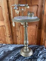 Full view of the vintage brass and marble telephone stand with ornate detailing and marble top.