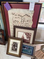 Overall view showing three framed pieces: one antique music manuscript, one framed print with figure, and one rustic photograph or print, placed together against a window.