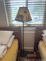 Full view of floor lamp next to window and bed showing height and design