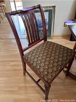 Front and side close-up of one mahogany Sheraton style dining chair showing vertical slat back and patterned upholstered seat