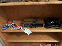 Overview of political buttons, Sony clock radio with wood grain finish, and binoculars with case on wooden shelf