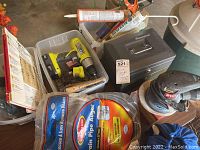 Overall view of lot including Ryobi drill, drain pipe auger, caulk gun, storage bin, and SentrySafe lock boxes