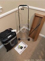 Full view of the Ativa paper shredder with mesh file holder and luggage cart behind it