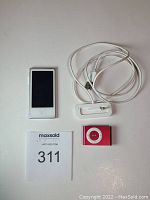 Photo showing both iPods and the original charger laid out side by side on a white surface with lot number card.