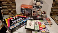 Lot overview including the Magic Show kit, Lotto Machine, Stress Doll, playing cards, Bridge notepad, casino game and books