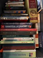 Stack of assorted books featuring titles on chemistry, accounting, classical composers, nursing, and investment among others