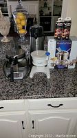 Full lot items on countertop including the Tramontina fondue set in original box, white Hawaii Ice ice shaver, electric waffle maker, coffee carafe, and two packs of Sterno fuel.