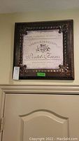 Framed 19x19 inch wall sign mounted above doorway, ornate dark frame with Chateau Loullian Pontet-Freres design.