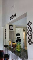 Wall plaque decor pieces mounted in kitchen and hallway areas above counters and doors.