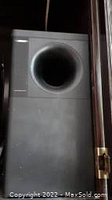 Close-up of Bose subwoofer showing large bass port, black color.