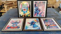 Five Lilo and Stitch themed diamond art pictures in frames placed on a table in natural light