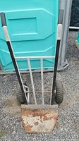 Front view of heavy duty fridge cart showing metal base plate, metal frame, and black rubber handles.