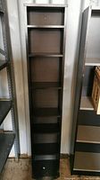 Front view of the tall narrow shelf unit showing all 5 shelves and base.