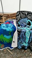 Two blankets draped over a stand showing Stitch character designs and fabric texture
