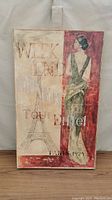 Clear photo showing the full wall art print with woman figure, Eiffel Tower and Paris 1924 text.