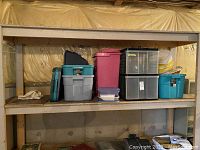 Overview of plastic storage bins and containers on wooden shelves in basement setting