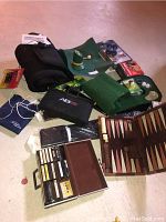 Overview of lot items including golf putting mat, AB wheel exerciser, backgammon set, cassette tapes, and other fitness and game equipment.