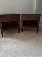 Pair of medium brown wood veneer nightstands side by side on carpet