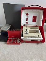 Wide shot showing sewing machine in case with accessory boxes and foot pedal