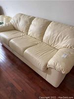 Front view of cream leather three-seat sofa