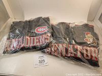 Photo showing both NHL track jackets, Ottawa Senators and Montreal Canadiens, sealed in plastic bags with visible logos and team names.