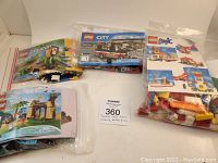 Photo of four Lego sets in plastic bags with original manuals, showing assorted colored Lego bricks from Moana, Creator, City and Basics lines. Pieces are loose and no original boxes are present.