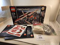Photo showing Lego Technic 42040 box, two instruction manuals, sticker sheet, and bags of pieces