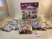 Lego Friends Brickmaster Treasure Hunt in Heartlake City box with 12 Lego Friends sets in resealable plastic bags with manuals visible